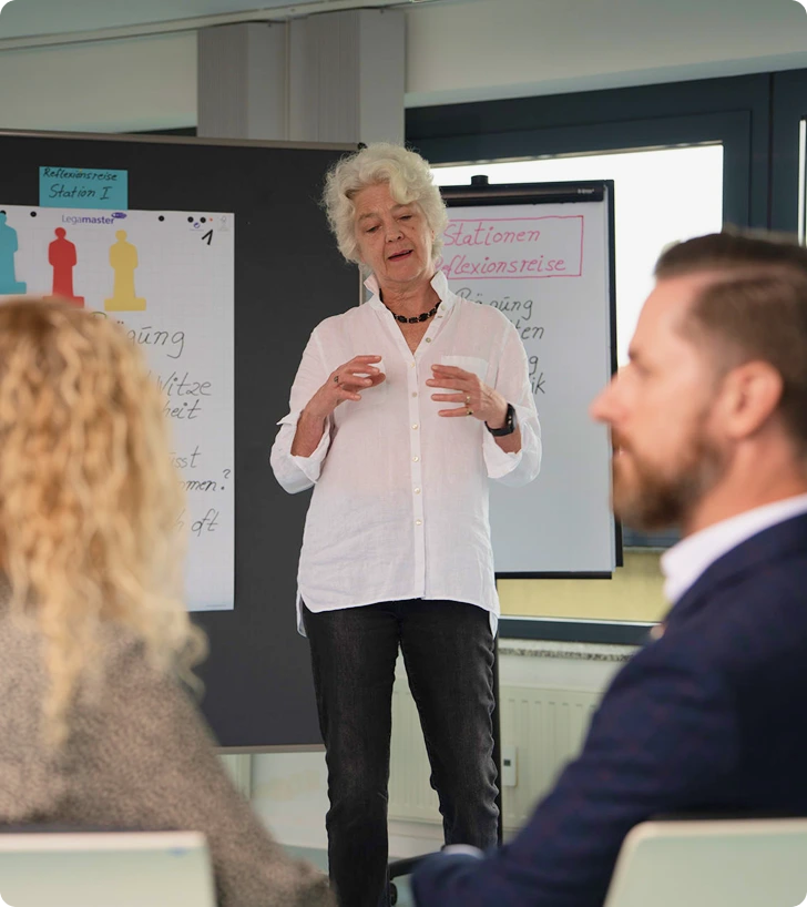 Coach vor einer Flipchart im Dialog